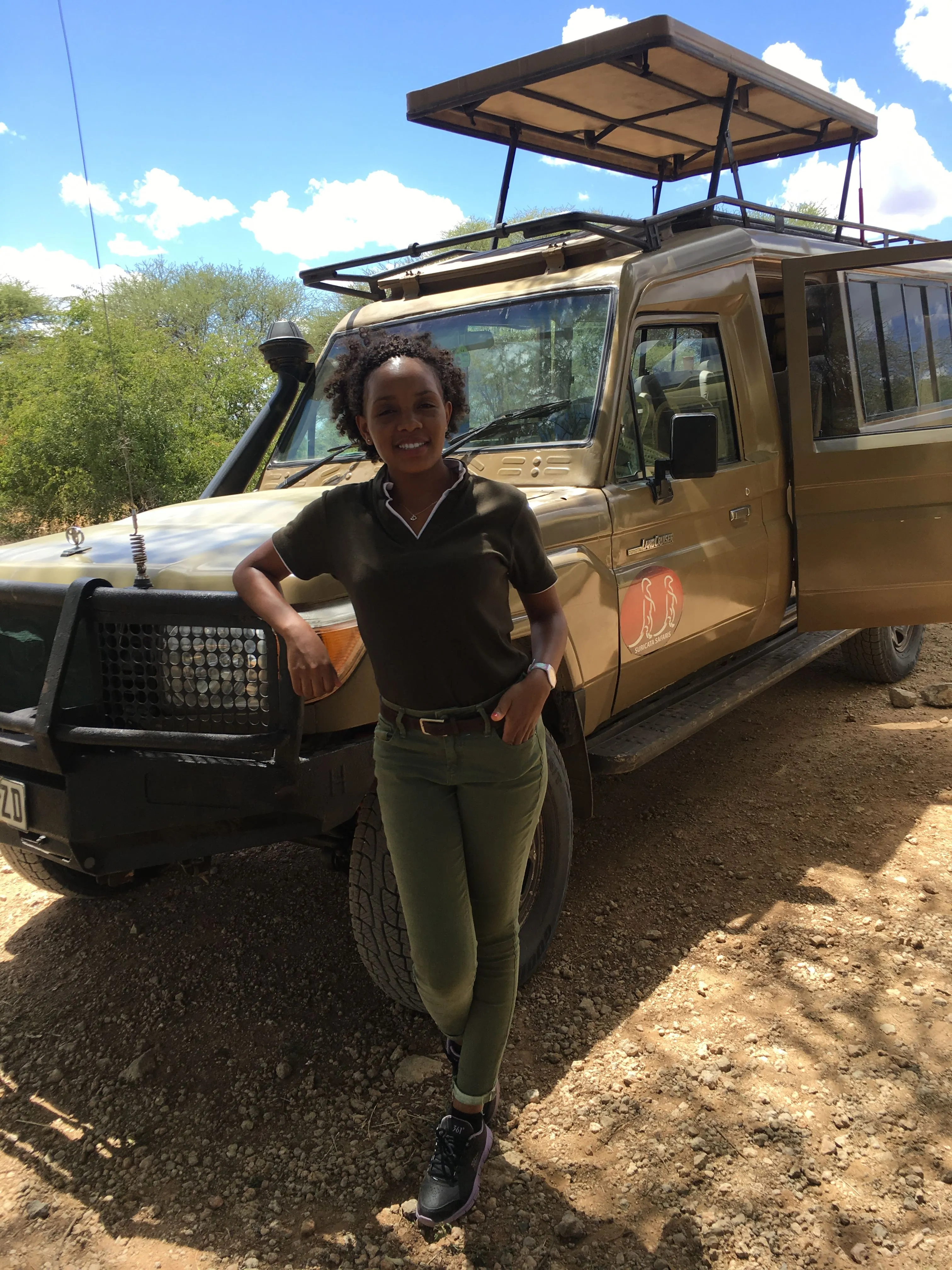 Vio standing beside a safari vehicle during the 2019 Tarangire journey