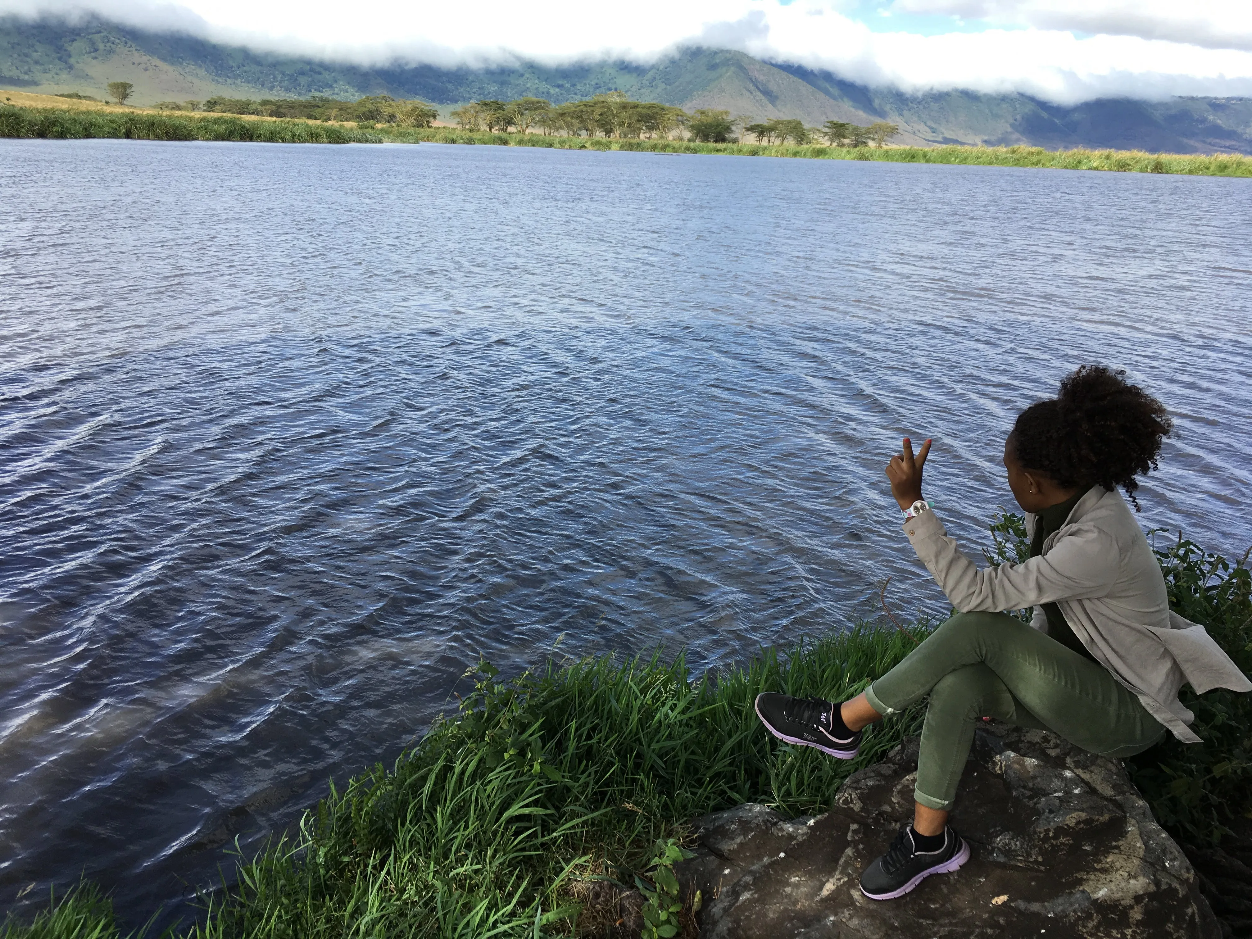 Vio sitting beside a lake in the Ngorongoro landscape
